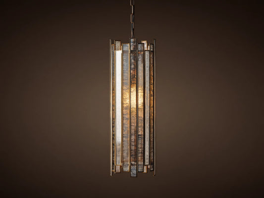 Laila Pendant, a cylindrical light with vertical antiqued mirrored-glass panels and an antique copper frame, glowing warmly.