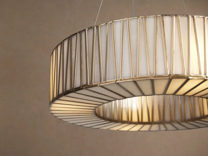 Jeunet Round Chandelier, antiqued brass frame with vertical glass panels, suspended against a light beige wall.