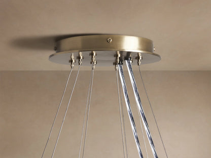 Close-up of Jeunet 2-Tier Round Chandelier, antiqued brass frame, illuminated white and clear rectangular glass panels.