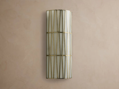 Jeunet Sconce, a rectangular wall-mounted light with an antiqued brass frame creating geometric patterns over illuminated white glass.