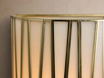 Jeunet Sconce, a long, rectangular wall-mounted light with an antiqued brass geometric frame and milky white glass panels.