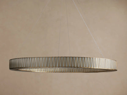 Jeunet Round Chandelier. Large, round antiqued brass chandelier with vertical glass panels, illuminated, hanging from cables.