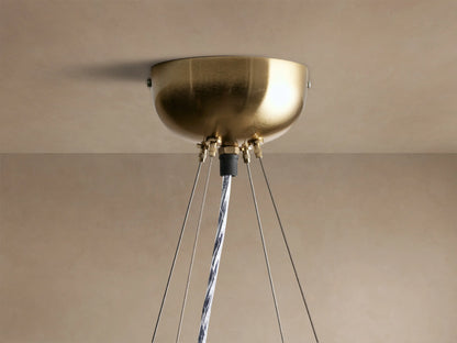 Jeunet Round Chandelier, round with antiqued brass geometric frame and white frosted glass panels, glowing warmly.