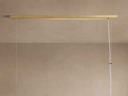 Angled close-up of Jeunet Rectangular Chandelier. Antiqued brass frame, vertical slats, and glowing soft light from within.