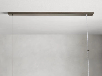 Rectangular chandelier with vertical glass panels and an iron frame. Features a warm glow from interior bulbs, suspended by a cable.