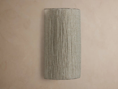 Romilly Beaded Sconce, vertical, elongated, warm light shining through its textured, light-colored strung glass beads on a neutral wall.