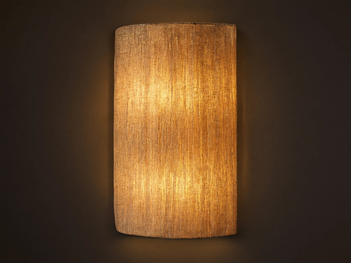 Romilly Beaded Sconce, vertical, elongated, warm light shining through its textured, light-colored strung glass beads on a neutral wall.