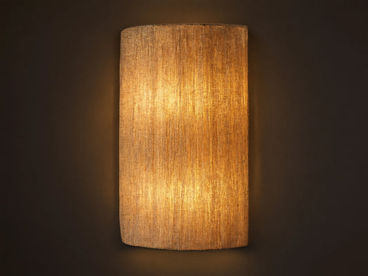 Romilly Beaded Sconce, vertical, elongated, warm light shining through its textured, light-colored strung glass beads on a neutral wall.
