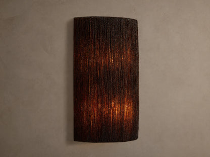 Romilly Beaded Sconce: Dark, rectangular fixture of individually strung glass beads, glowing warmly from within on a light wall.
