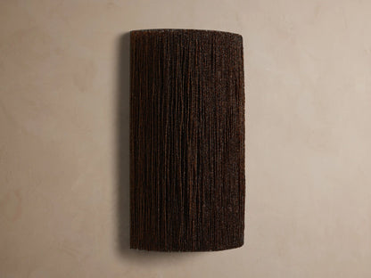 Romilly Beaded Sconce: Dark, rectangular fixture of individually strung glass beads, glowing warmly from within on a light wall.