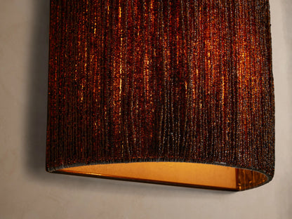 Romilly Beaded Sconce: curved, rectangular, dark brown glass-beaded wall light, mounted vertically on a light wall.