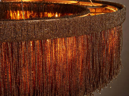 Close-up of Romilly Round Chandelier with intricate bronze glass bead fringe glowing warmly from within.