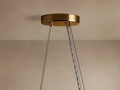 Romilly Round Chandelier: Close-up of its round brass ceiling mount with several gray suspension cables hanging down.
