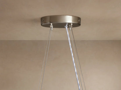Romilly Round Chandelier: Close-up of brushed silver ceiling canopy with suspension wires & clear electrical cord on a beige ceiling.