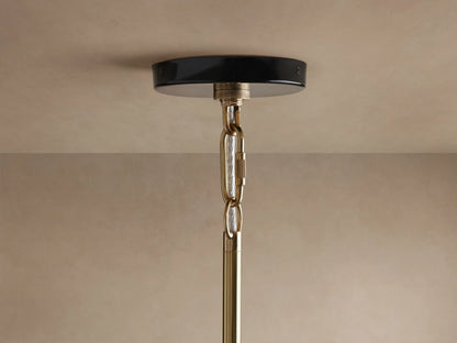 Close-up of Bonham Pendant featuring a glossy black exterior and a luminous brass interior with a warm glowing light.