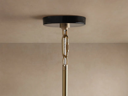 Bonham Pendant: close-up, black powder-coated top, shining brass interior with warm glowing bulb, viewed from below.