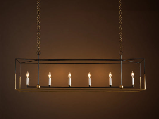 Holt Linear Chandelier. Black rectangular frame with antique brass base, hanging from chains. Six illuminated candle-style bulbs.
