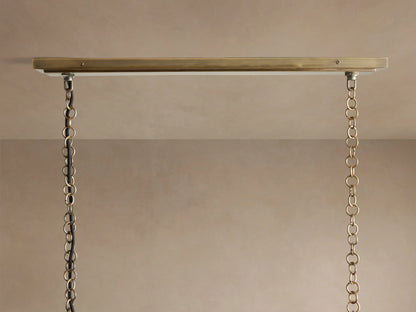 Close-up of Holt Linear Chandelier. Two-toned antiqued brass and black frame with two illuminated candelabra bulbs.