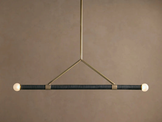 Randall Leather Pendant: Dark leather-wrapped horizontal bar with two frosted globe bulbs, suspended by a burnished brass frame.
