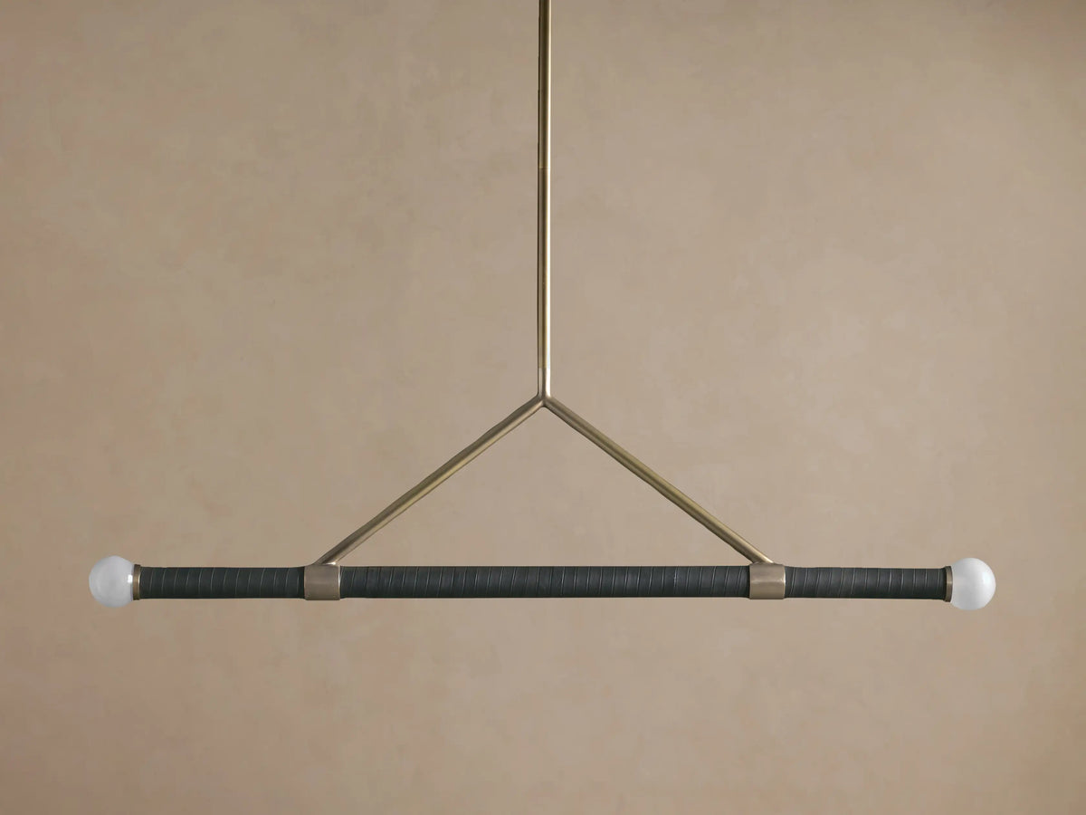 Randall Leather Pendant: Dark leather-wrapped horizontal bar with two frosted globe bulbs, suspended by a burnished brass frame.