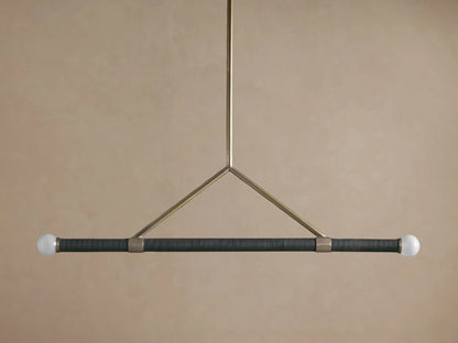 Randall Leather Pendant: Dark leather-wrapped horizontal bar with two frosted globe bulbs, suspended by a burnished brass frame.