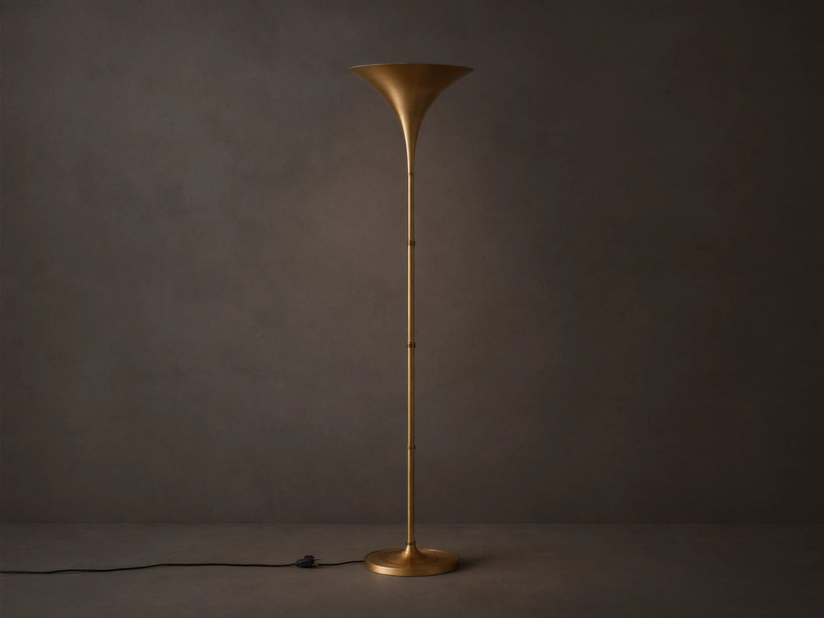Tall Tultz Floor Lamp with burnished brass finish, tulip-shaped shade, slender pole, and round base on wooden floor.