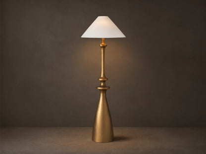 Murphy Floor Lamp with a brass-finished cast aluminum base and stem, topped with a white conical linen shade, standing on wood floor.