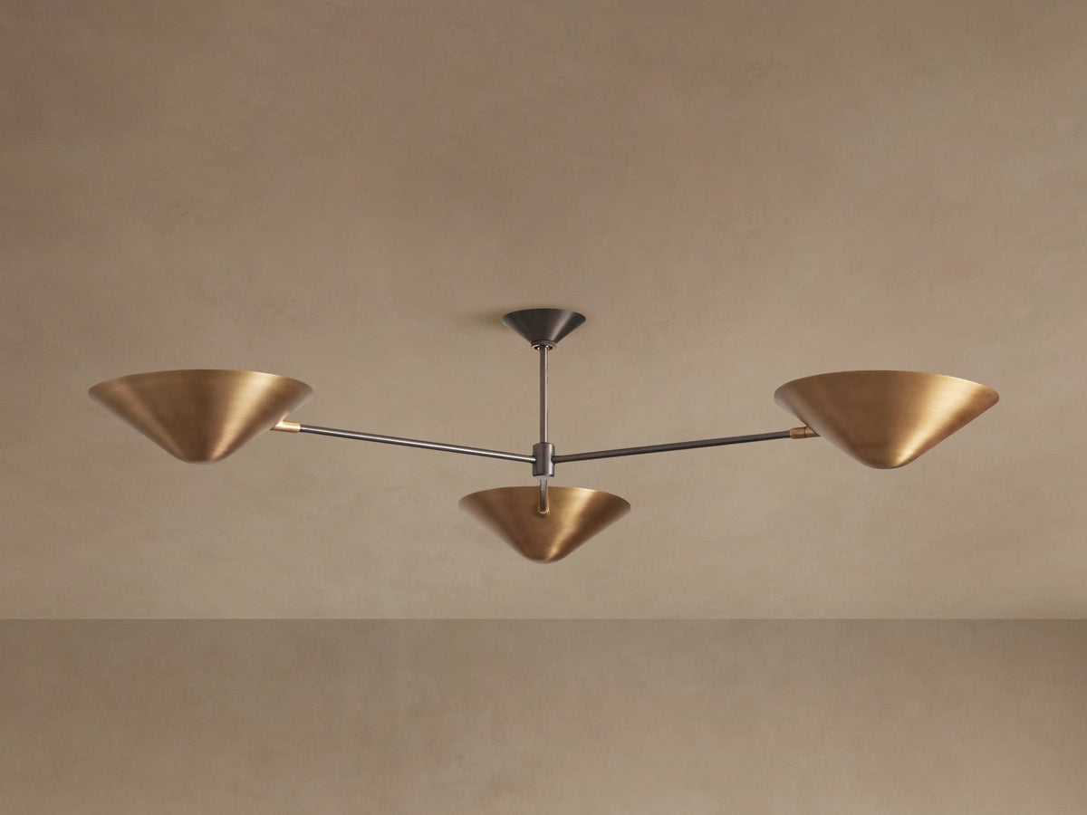 Simms Flush Mount: 3-light fixture with antiqued brass cone shades and dark grey arms, mounted to a beige ceiling.
