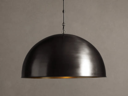 Watley Dome Pendant: Large dark dome with a polished, glowing antique brass interior, suspended from a dark chain.