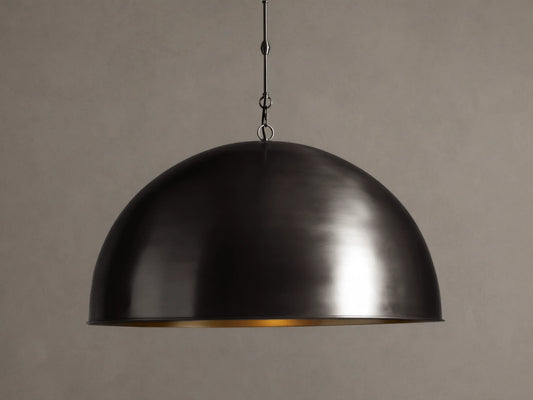 Watley Dome Pendant: Large dark dome with a polished, glowing antique brass interior, suspended from a dark chain.