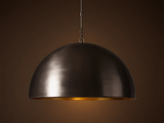 Watley Dome Pendant: Large dark dome with a polished, glowing antique brass interior, suspended from a dark chain.
