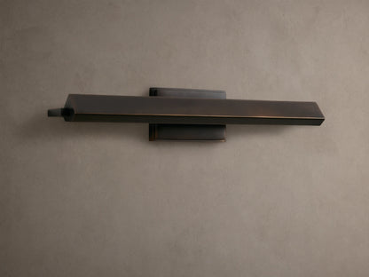 Zaeden Picture Light: Bronze-plated iron horizontal bar light mounted on a neutral wall, highlighting its metallic finish.