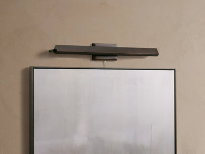Zaeden Picture Light: sleek, dark bronze horizontal bar fixture mounted on a beige wall above a framed object.