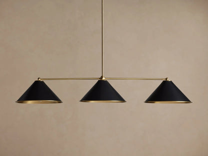 Arno Linear Chandelier with three matte black cone shades and polished brass accents, centered against a neutral wall.
