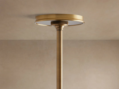 Close-up of Arno Linear Chandelier featuring a matte black conical shade with a shiny brass interior, suspended from a brass rod.