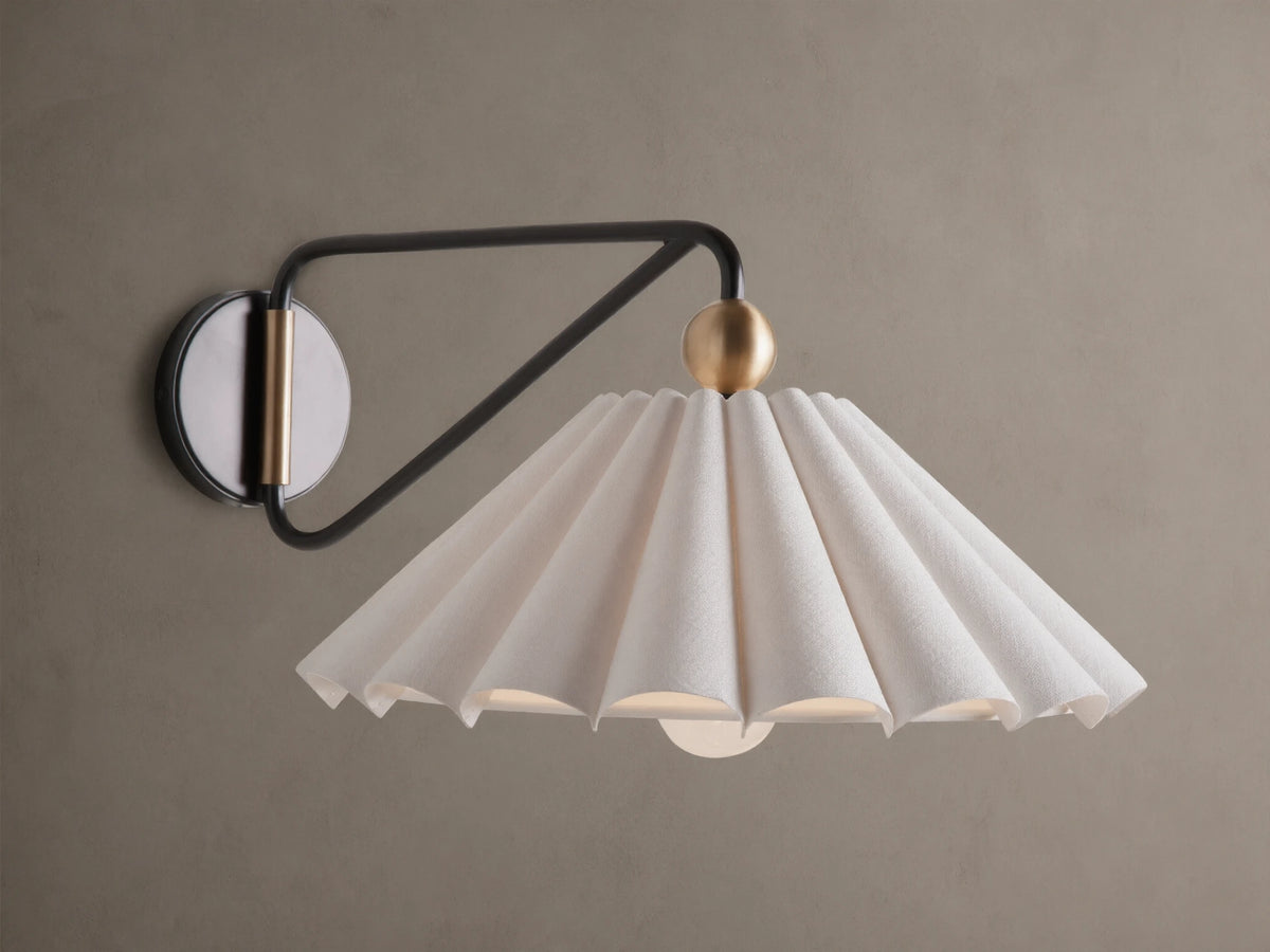 Illuminated Haylen Sconce: black metal arm, circular backplate with antique brass, pleated cream fabric shade.