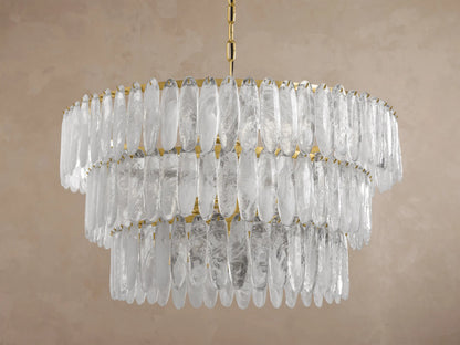 Close-up of a circular brass chandelier featuring numerous hanging clear textured glass panels, illuminated from within.