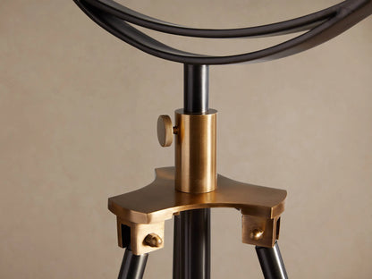 Close-up of Retro Tripod Floor Lamp's warm, shiny brass shade interior and glowing Edison filament bulb.