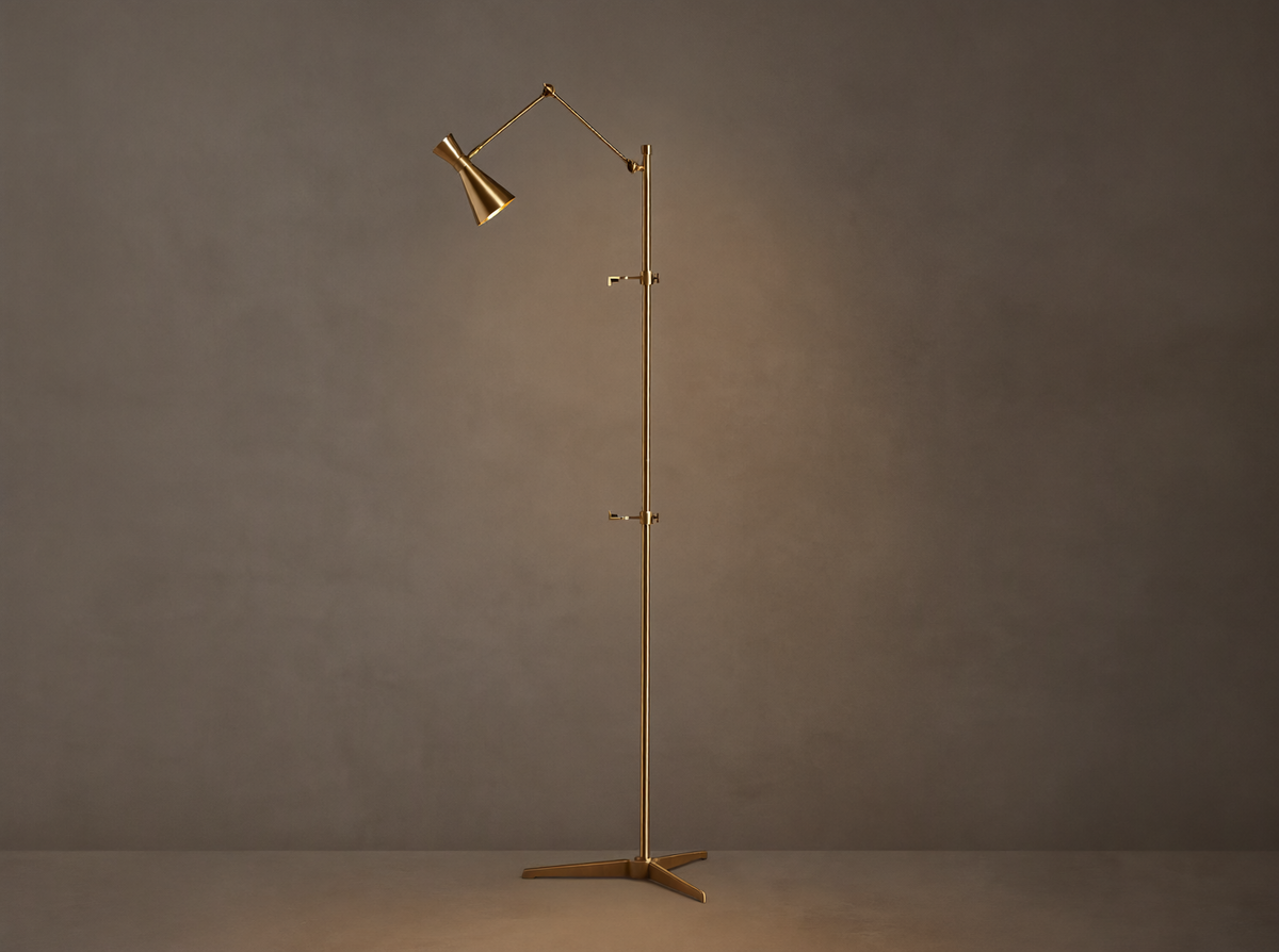 Tall, slender gold brass Jaxtyn Easel Floor Lamp with an angled light head, X-base, and small art display hooks.