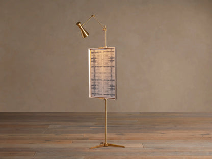 Close-up of the Jaxtyn Easel Floor Lamp's adjustable cast brass art display support and vertical pole with adjustment knob.
