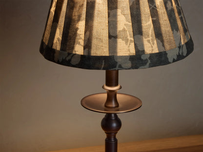 Front view of the Bronze Winslow Accent Table Lamp with a pleated dark gray fabric shade featuring a light floral pattern.