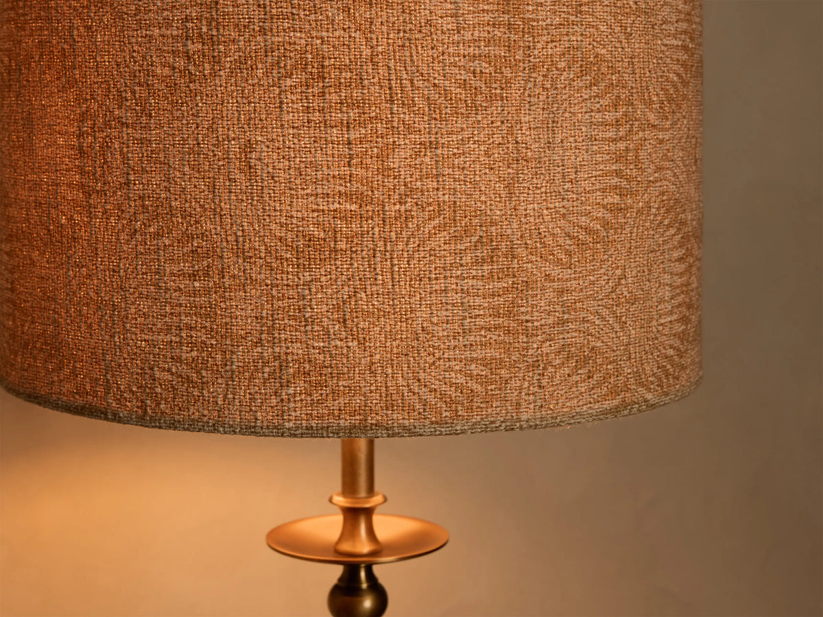 Close-up of the bronze-finished iron base of the Winslow Table Lamp, detailing a sculpted column and decorative disk.