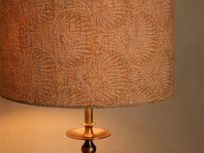 Close-up of the bronze-finished iron base of the Winslow Table Lamp, detailing a sculpted column and decorative disk.