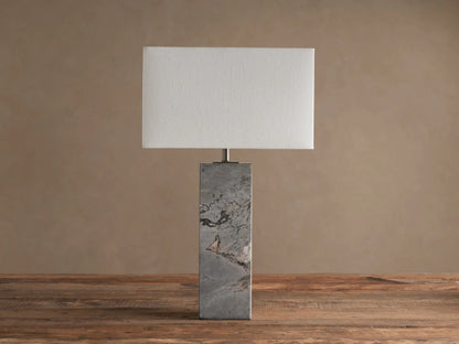 Oren Table Lamp with rectangular white linen shade and gray natural stone base with veining, on a rustic wooden table.