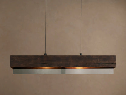 Lena Linear Chandelier: a dark alder wood beam with ochre finish and mirrored glass bottom, emitting warm light, suspended by two black cords.