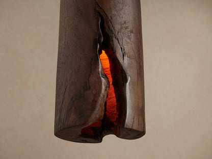 Dedalo Pendant: cylindrical milpa wood light in ochre/brown, natural texture, glowing from within, hanging from cord.