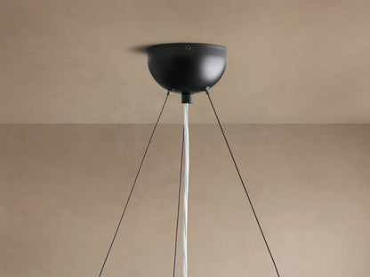 Arruga Chandelier, view from below. Dome of natural milpa wood with rich brown grain. Single globe bulb, silvered at bottom, glowing warm.