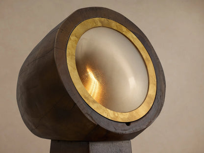 Agustin Floor Lamp: Dark faceted wood base, cylindrical top, with round opaque glass light framed by a golden ochre ring.