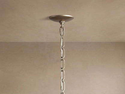 Margolis Large Pendant. White segmented hand-blown glass orb, encased by a brass-finish iron frame, against a neutral background.