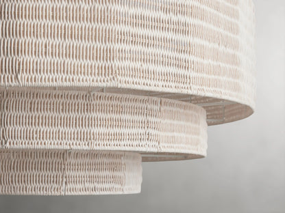 Paloma Chandelier with layered handwoven rattan shade, featuring a tiered circular design in a light beige color, hanging on a metal chain.